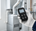 Technician using a portable gas detector in a bright utility room